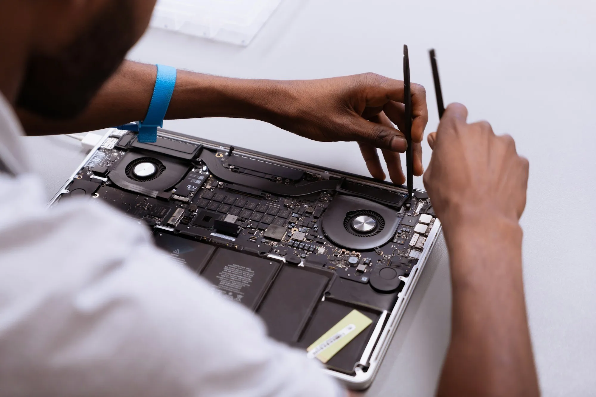 Hands working inside an open laptop